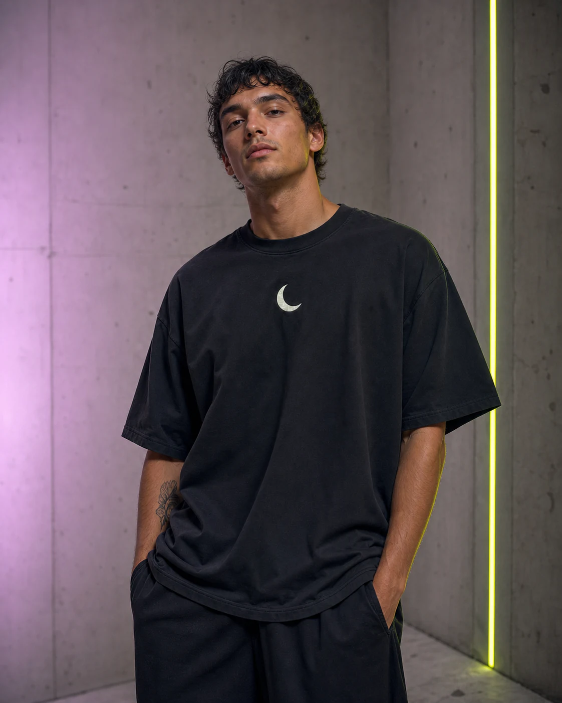 Young man wearing the same black crescent T-shirt in a fashion campaign
